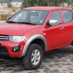 Vista real de una camioneta roja con fangueras para camioneta mitsubishi l200 del 2006 al 2015