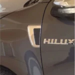 Riñonera cromada para camioneta toyota hilux instalada en la parte izquierda de una camioneta